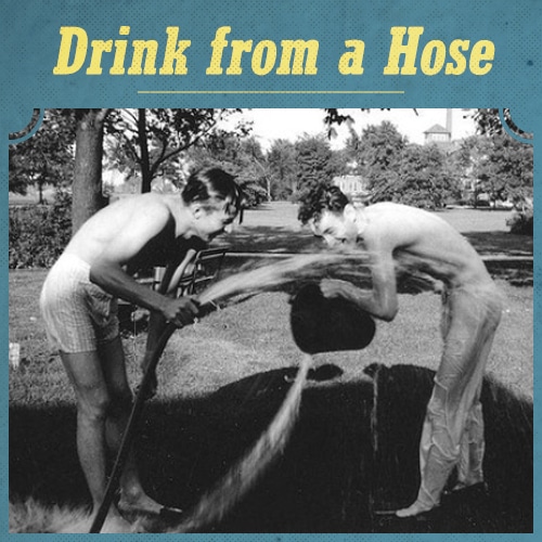 Vintage men drinking water from hose.