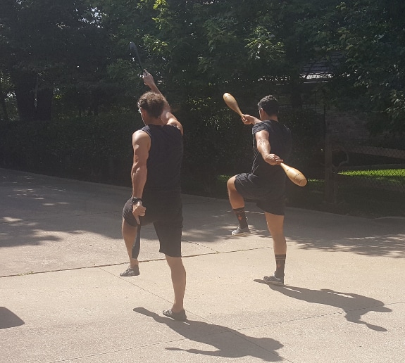 Men marching with indian clubs workout training.