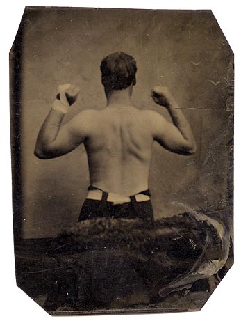 An old photograph of a man with his arms raised in celebration.