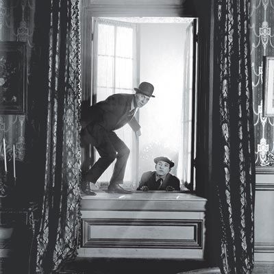 Vintage burglars breaking into window home.