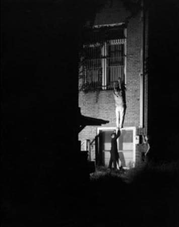 Vintage burglars being hoisted up to balcony.