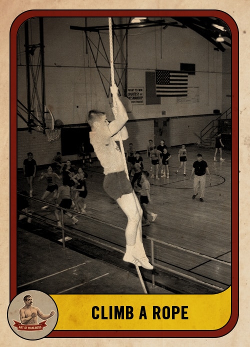 Vintage young man climbing rope in gym class.