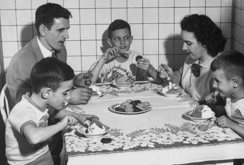 Vintage family eating dessert at dinner table.