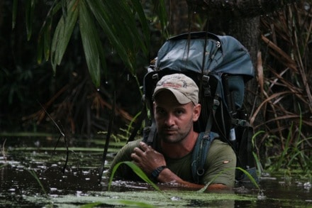 A modern day adventurer with a backpack in a swamp.