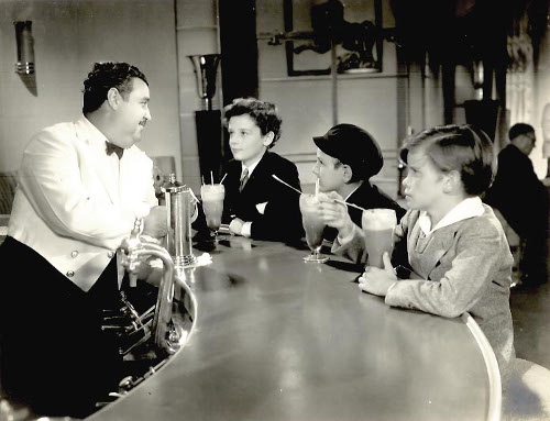 Vintage kids at soda fountain drinking egg cream.