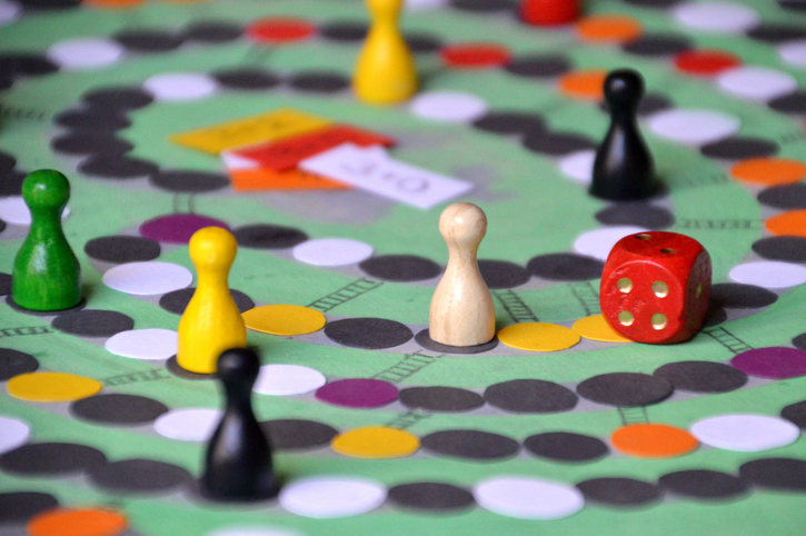 A board game with wooden pieces on a green table is a classic example of how simple pleasures in life can bring joy.
