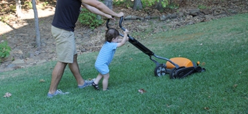 IMG_1131 Young boy helping dad mow lawn.