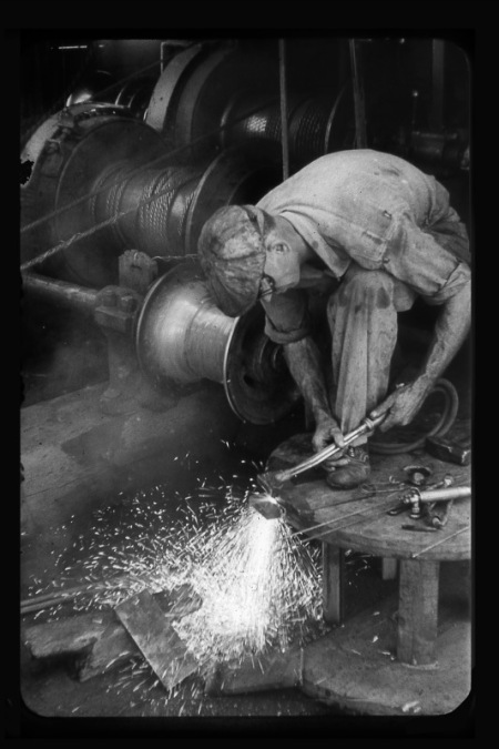 manwork Vintage man welding in factory.