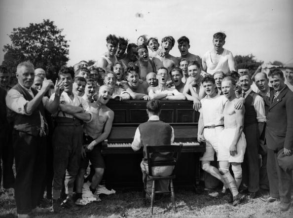 Vantage group singing song and one is playing piano.