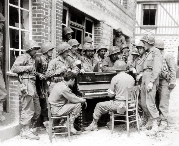 Vantage group of soldiers listening to piano.