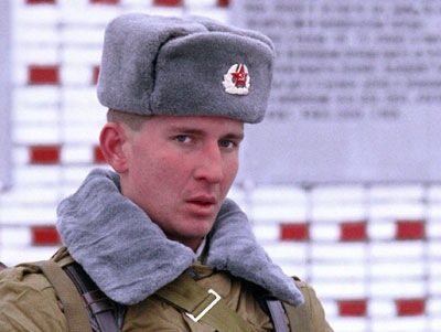 Soviet soldier wearing gray ushanka winter hat.