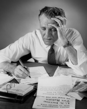 taxes Vintage man looking stressed to see taxes papers.