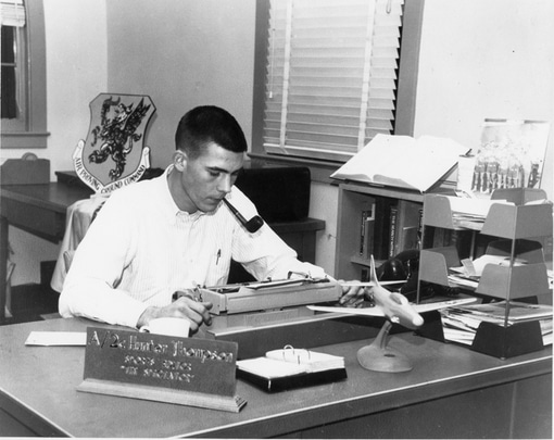 Young hunters thompson writing on typewriter at desk with tobacco pipe in his mouth.