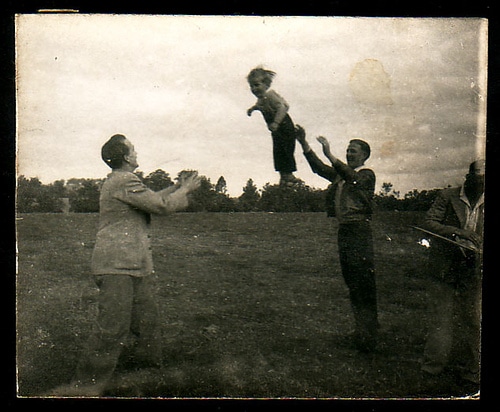 toss Vintage men tossing young boy between them.