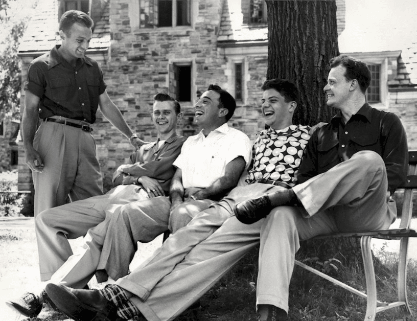 Vintage young laughing friends talking and on sitting bench.