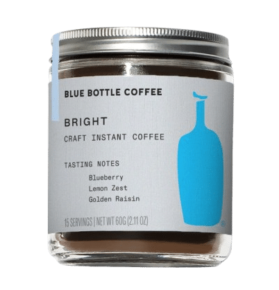 A glass jar of Blue Bottle Coffee Bright Instant Coffee features a label with tasting notes of blueberry, lemon zest, and golden raisin—showcasing why it's considered some of the best instant coffee available.